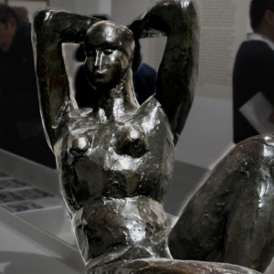 sculture d'une femme a la posture posée sur une banquette avec les mains derrière la tête