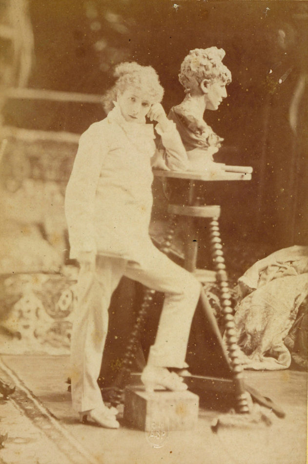 Sarah Bernhardt posant à côté de la sculpture son buste